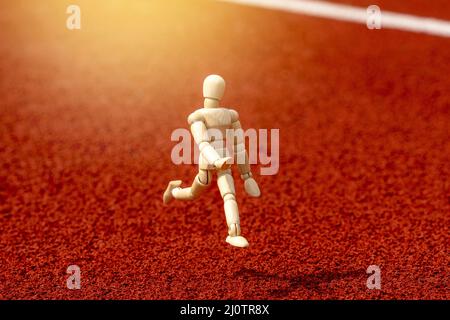 Figura di legno che corre sul tracciato dello stadio Foto Stock
