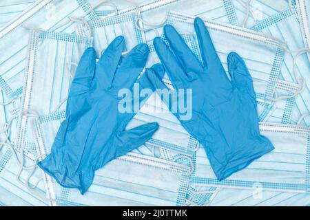 Un paio di guanti in lattice medico blu sottile e un sacco di maschera medica Foto Stock