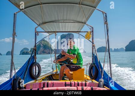 Tour in barca tra le pittoresche isole calcaree nella baia di Phang Nga. Questa è una delle destinazioni turistiche più iconiche di Thailands. Foto Stock