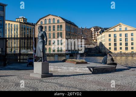 La gente gode il sole nel vecchio paesaggio industriale di Norrkoping durante l'inizio della primavera. Norrkoping è una storica città industriale svedese. Foto Stock