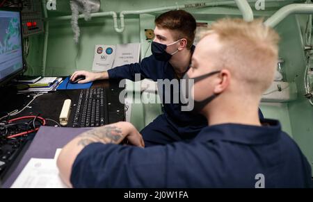 MAR DELLE FILIPPINE (Gen. 29, 2022) Mate Airman Apprentice William Breaulauer, a destra, da Chicago, e Mate 3rd Class Brandyn Taylor, a sinistra, da Dothan, al. Tenere traccia del tempo durante l'esercizio di formazione bilaterale Ship Anti-Submarine Warfare Readiness Effectiveness Measuring (SHAREM) con il Japan Maritime Self Defense Force.Fitzgerald è in fase di implementazione programmata nell'area delle operazioni della flotta USA 7th per migliorare l'interoperabilità con alleanze e partnership, fungendo da forza di pronto intervento a supporto di Una regione indopacifica libera e aperta. (STATI UNITI Navy foto di Foto Stock