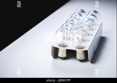 New incandescent car lamps for car sizes in paper-packed lot on a grey gradient background Stock Photo