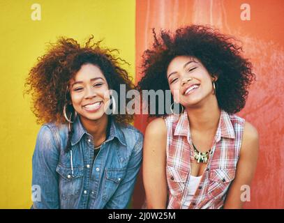 Amici alla moda. Ritratto di due giovani amici in posa su uno sfondo colorato. Foto Stock