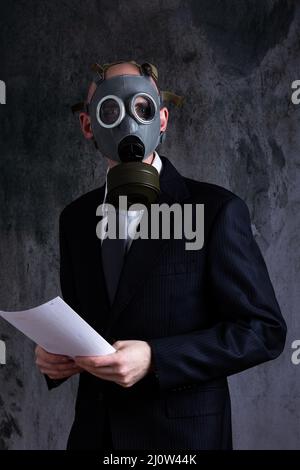 Metà sezione di uomo che indossa maschera a gas e che tiene carte Foto Stock