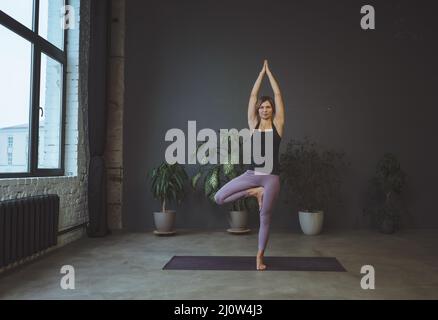 Cosciente del corpo. Corpo umano, posizione fisica, concetto di benessere. Yoga, giovane donna in piedi in un asana. Foto Stock