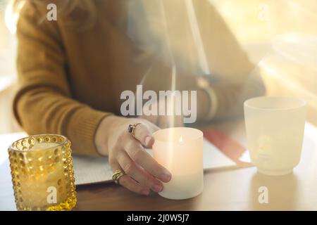 Immagine sfocata di donna candela profumata fulmine mentre lavora a distanza a casa Foto Stock