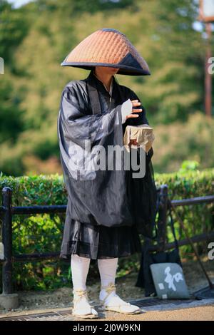Monaco buddista che canta sutra e raccoglie donazioni in via Kyoto. Giappone Foto Stock