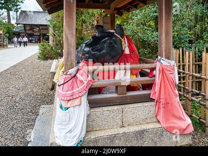 La statua del bue sdraiata sotto il tetto del santuario di Kitano Tenmangu. Kyoto. Giappone Foto Stock