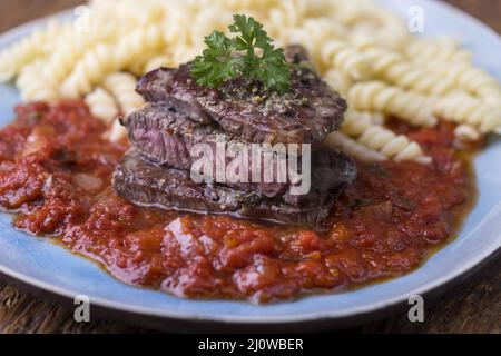 Bistecca a fette con pasta di spirelli Foto Stock