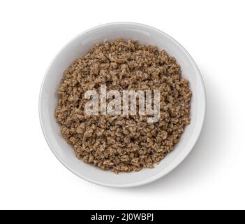 Ciotola di fiocchi di grano saraceno isolato su sfondo bianco, vista dall'alto Foto Stock