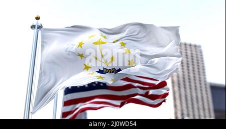 La bandiera dello stato americano del Rhode Island sventola nel vento con la bandiera americana sfocata sullo sfondo. Rhode Island era un Foto Stock