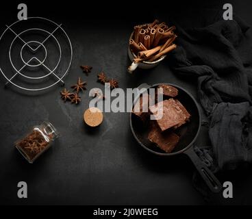 Pezzi di brownie al forno in una padella nera in metallo sul tavolo, vista dall'alto Foto Stock