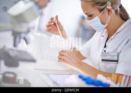 Rompere i confini scientifici con la sua ricerca. Un ricercatore scientifico che lavora in laboratorio. Foto Stock