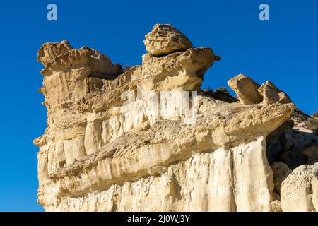 Una vista delle famose erosioni di arenaria e degli hoodoos a Bolnuevo sotto un cielo blu chiaro Foto Stock