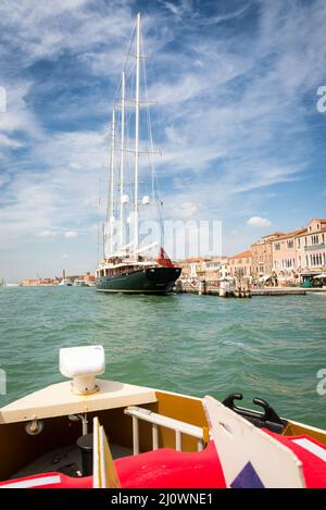 An old wooden sailing ship moored on the island of Giudecca, opposite of the St. Marks Square in Venice, Italy. On a cloudy day Stock Photo