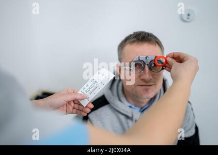 Esame della vista del paziente. Esame visivo. Optometristo che controlla la vista del paziente e la correzione della vista. Paziente sottoposto a controllo visivo Foto Stock