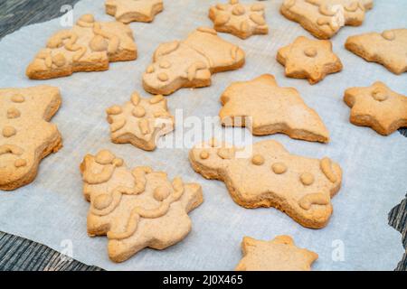 Gingerbread Cookies Natale figure dalla pasta cotta al forno. Sulla carta da forno. Il concetto di pasti di Natale. Foto Stock