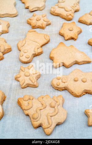 Gingerbread Cookies Natale figure dalla pasta cotta al forno. Sulla carta da forno. Il concetto di pasti di Natale. Foto Stock