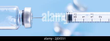Siringa medica con un ago e un bollte con il vaccino. Foto Stock