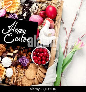 Tavolo di Pasqua con un assortimento di dolci e dolci. Concetto di cibo per le vacanze primaverili. Congratulazioni sfondo di pasqua. Vista dall'alto, piatto Foto Stock
