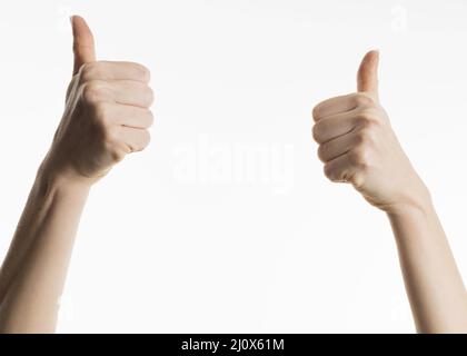 Le mani della vista frontale mostrano i pollici verso l'alto. Concetto di foto di alta qualità Foto Stock