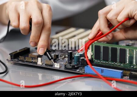 Tecnico femminile che ripara la scheda madre del computer. Foto di alta qualità Foto Stock