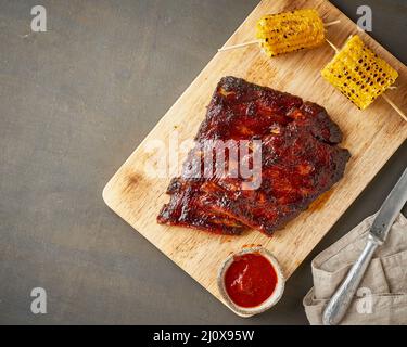 Costolette di maiale al barbecue. Ricetta di cottura lenta. Sfondo marrone Foto Stock