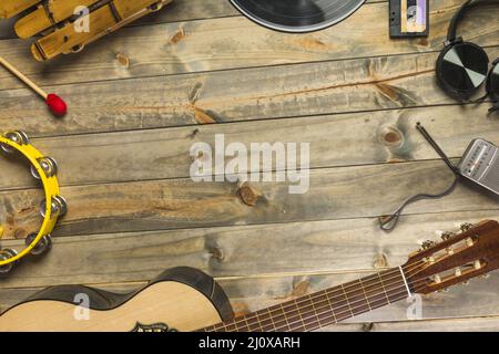 Primo piano cuffia chitarra tambourine xylophone cuffia radio tavolo in legno con spazio testo Foto Stock