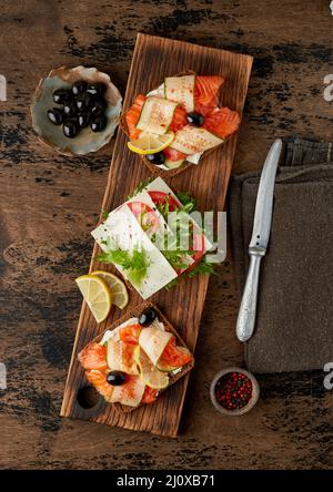 Smorrebrod - panini tradizionali danesi. Pane di segale nero con salmone Foto Stock