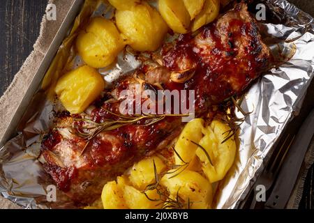 Costolette di maiale piccanti al barbecue e patate schiacciate. Ricetta di cottura lenta. Foto Stock