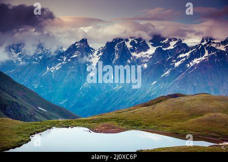 Fantastico paesaggio con lago Koruldi e cielo nuvoloso al piede di Mt. Ushba. Svaneti superiore, Mestia, Georgia, l'Europa. Montagne del Caucaso. Bellezza w Foto Stock