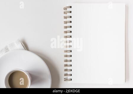 Tazza di caffè vuota spirale blocco note sfondo bianco. Concetto di foto di alta qualità Foto Stock