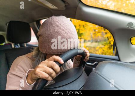 Donna asiatica matura si addormentò alla macchina su un volante. Addormentando la donna asiatica esausta che dorme in macchina. Bionda centrale Foto Stock