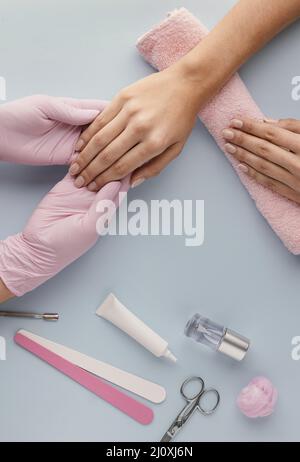 Primo piano manicurista che tiene la mano del cliente. Concetto di foto di alta qualità Foto Stock