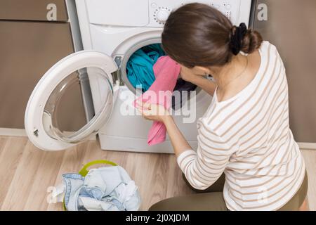 Signora che prende i vestiti fuori lavatrice. Foto di alta qualità Foto Stock