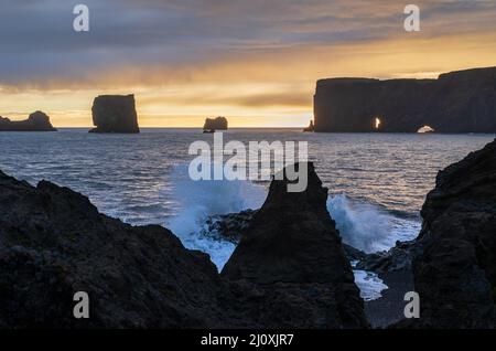 Pittoresca autunno sera vista del Capo Dyrholaey, spiaggia e formazioni rocciose. Vik, Islanda del Sud. Foto Stock
