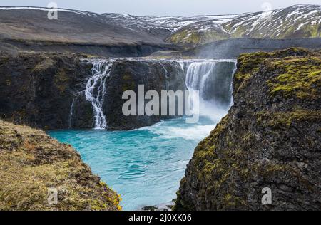 Pittoresca cascata Sigoldufoss vista autunno. Stagione che cambia nelle Highlands meridionali dell'Islanda. Foto Stock