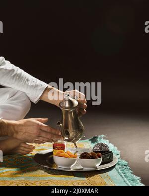 Man bianco che versa tè piccola tazza vista frontale. Concetto di foto di alta qualità Foto Stock