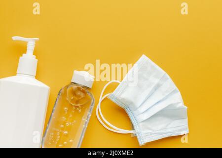 Maschera medica piatta con disinfettante per le mani per bottiglie di liquido. Concetto di foto di alta qualità Foto Stock