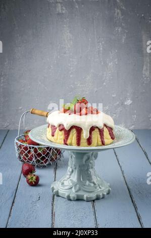 Cheesecake tradizionale tedesca con frutta a fragola servita da vicino in un piatto di torta su un tavolo di legno Foto Stock