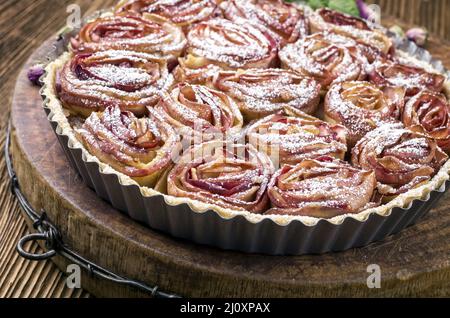 Tradizionale francese torta di mele aux pommes bouquet de rose servito come primo piano in classico piatto di supporto Foto Stock