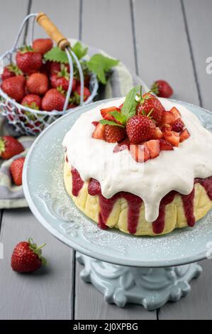 Cheesecake tradizionale tedesca con frutta a fragola servita da vicino in un piatto di torta su un tavolo di legno Foto Stock