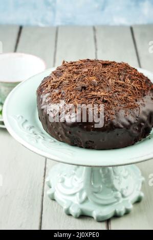 Tradizionale torta austriaca al cioccolato Sacher con briciole servita da vicino su un piatto in ceramica Foto Stock