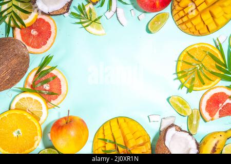 Sfondo di frutta estiva. Frutti tropicali vari su sfondo turchese - mango, cocco, mele, avocado, limone, arancio, pompelmo, ananas, wi Foto Stock