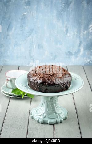 Tradizionale torta austriaca al cioccolato Sacher con briciole servita da vicino su un piatto di torta in ceramica con spazio copia Foto Stock