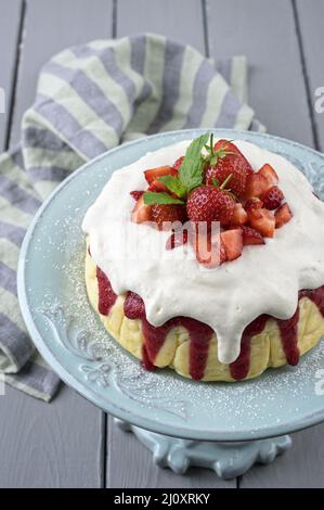 Cheesecake tradizionale tedesca con frutta a fragola servita da vicino in un piatto di torta su un legno Foto Stock