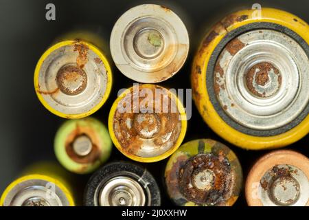 Primo piano della batteria usata con tracce di ruggine e corrosione. Concetto di rifiuti pericolosi elettronici Foto Stock