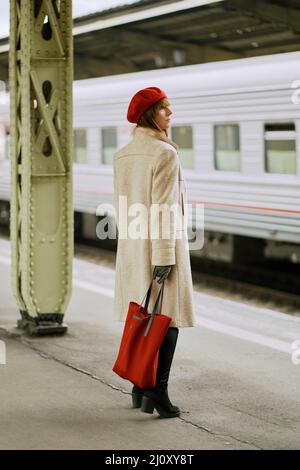 Stazione ferroviaria. Bella ragazza è in attesa di treno. La donna viaggia leggero. Foto Stock
