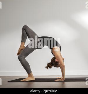 Donna adulta che fa yoga a casa. Foto di alta qualità Foto Stock