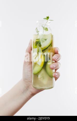 Mano con una bottiglia di limonata di frutta. Foto di alta qualità Foto Stock